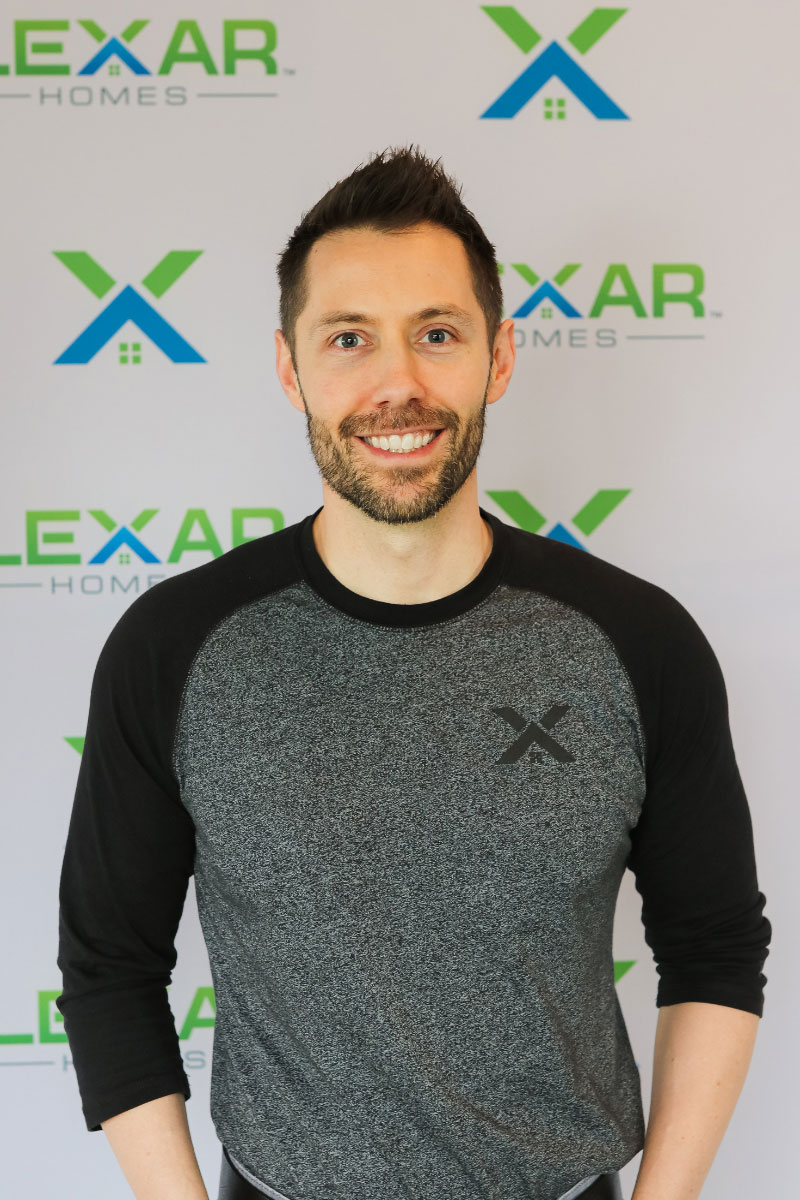 Corporate headshot of man standing with a backdrop